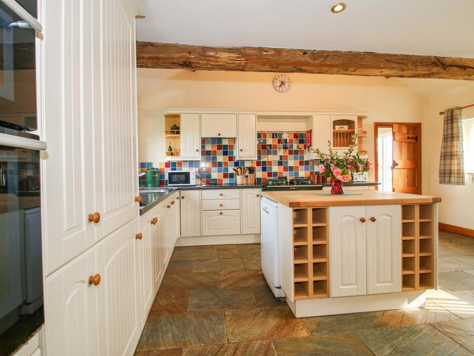 A kitchen with cabinets and an island at The Barn in Cockshutt near Ellesmere