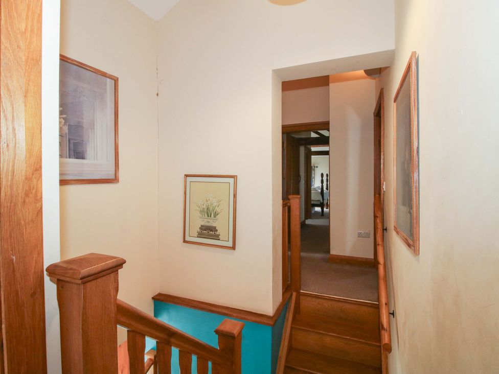 A hallway with staircase and wall art at The Barn in Cockshutt near Ellesmere