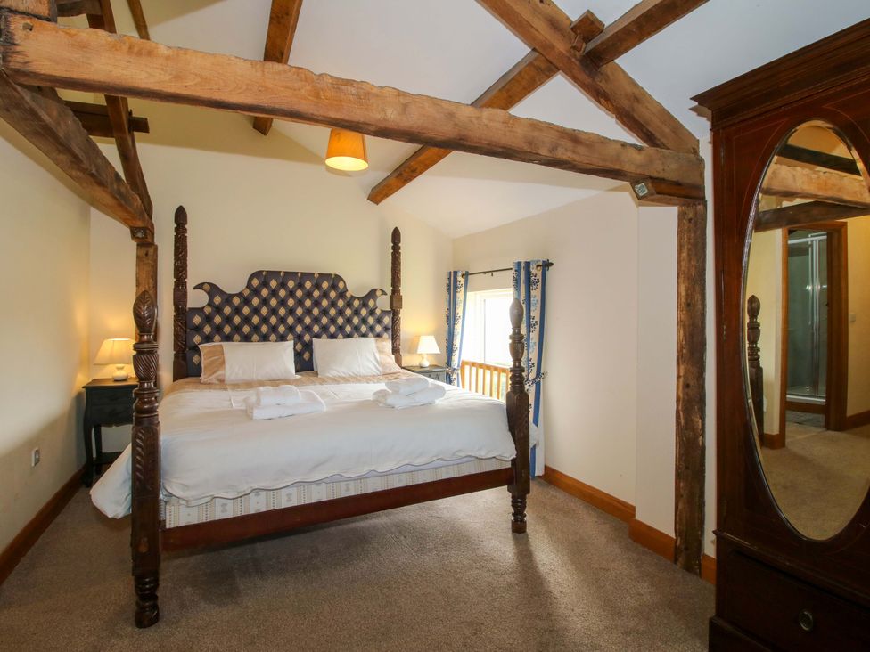 A bedroom with a bed and wardrobe at The Barn in Cockshutt near Ellesmere
