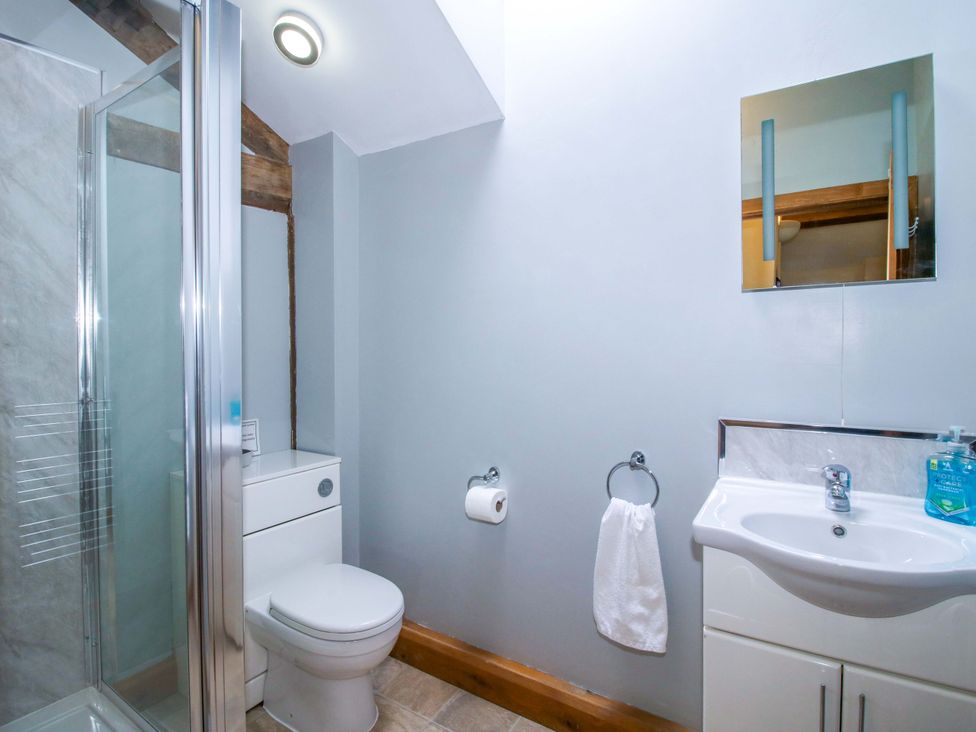 A bathroom with shower, toilet, and sink at The Barn Cockshutt near Ellesmere