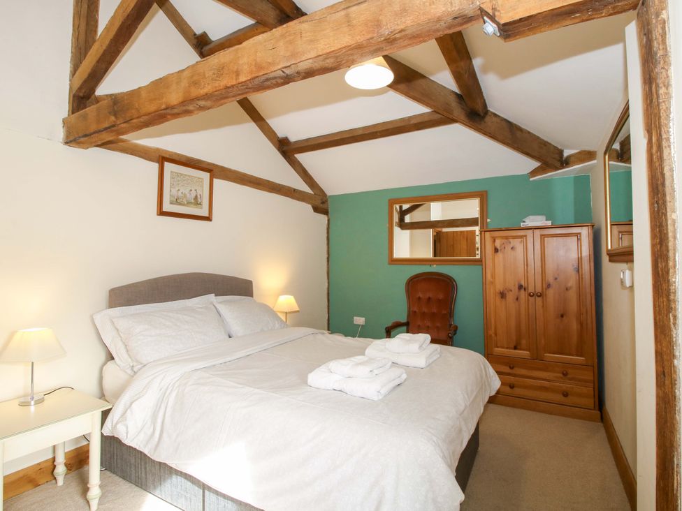 A bedroom with a bed and wardrobe at The Barn Cockshutt near Ellesmere