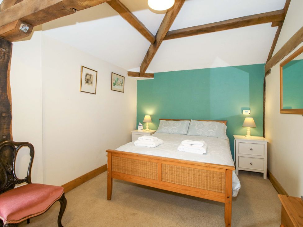 A bedroom with a bed and nightstand at The Barn in Cockshutt near Ellesmere