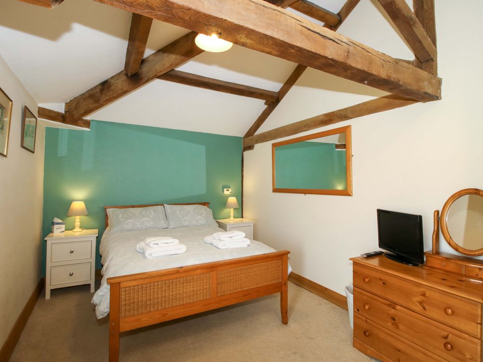 A bedroom with a bed and furniture at The Barn Cockshutt near Ellesmere