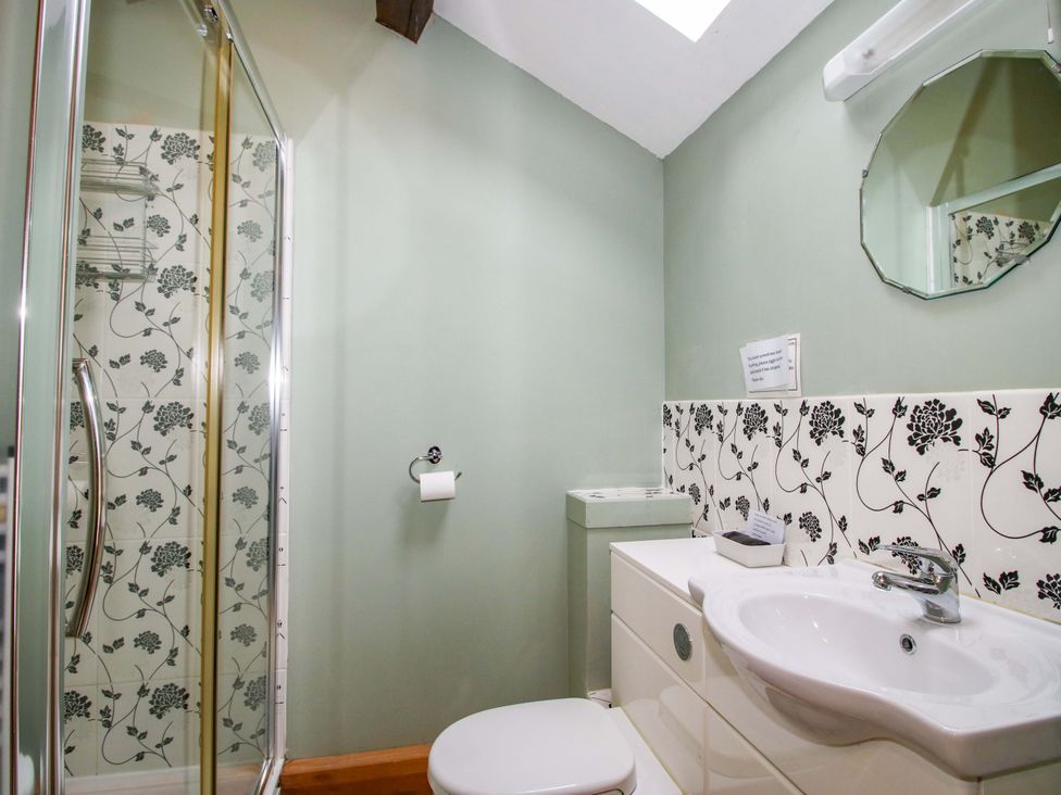 A bathroom featuring a shower, toilet, and sink at The Barn in Cockshutt near Ellesmere