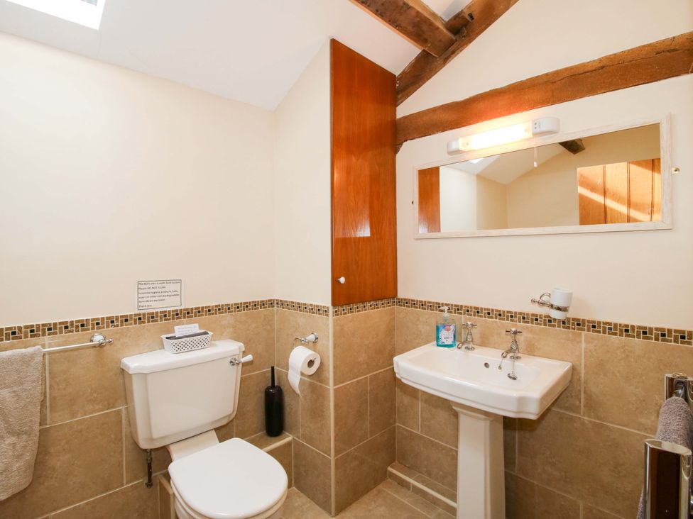 A bathroom with a toilet and sink at The Barn in Cockshutt near Ellesmere