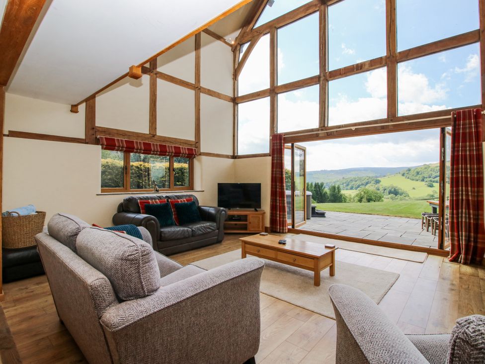 A living room with large windows and furniture at The Hayloft in Bleddfa near Knighton