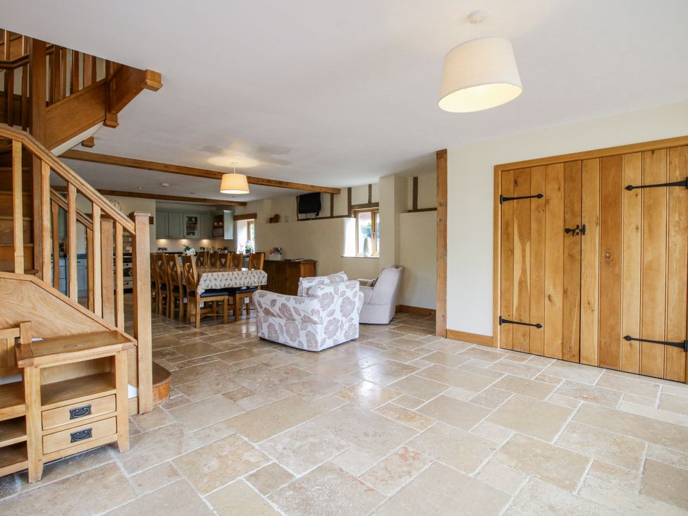 A living room with a dining area and staircase at The Hayloft in Bleddfa near Knighton