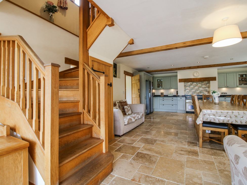 An open plan living room with a kitchen and staircase at The Hayloft in Bleddfa near Knighton
