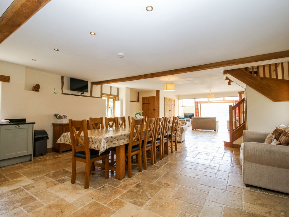 A dining room with a long table and chairs at The Hayloft in Bleddfa near Knighton