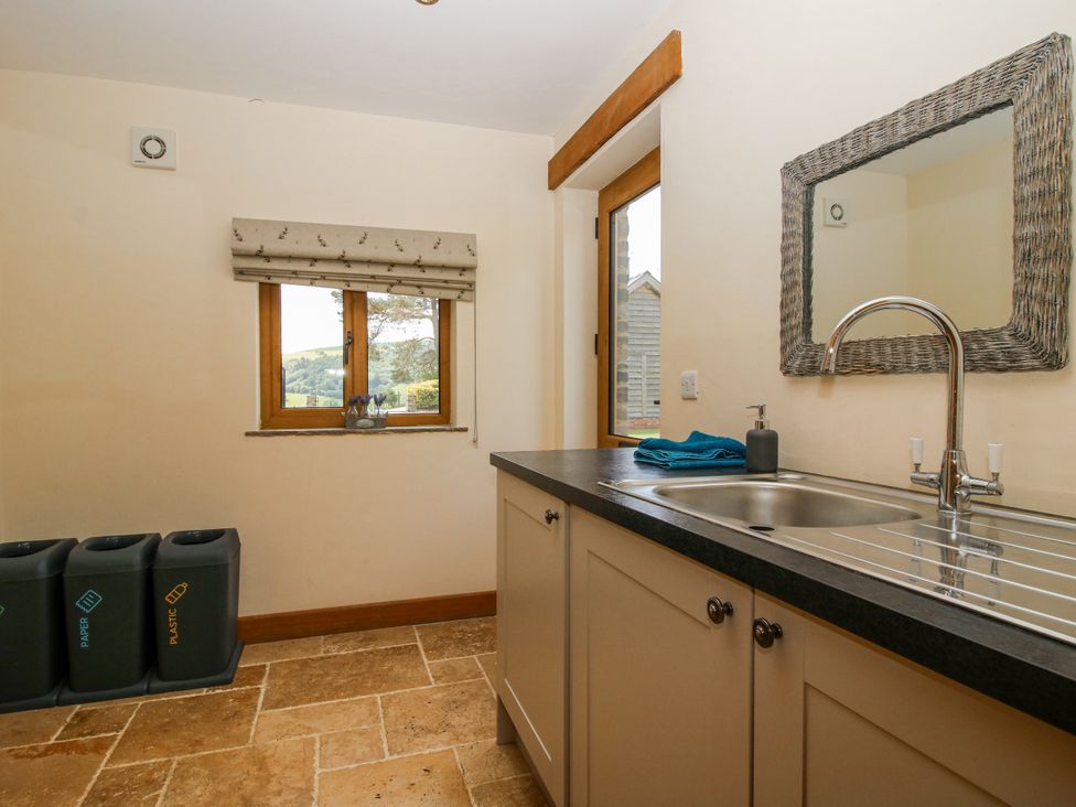 A utility room with a sink and recycling bins at The Hayloft in Bleddfa near Knighton