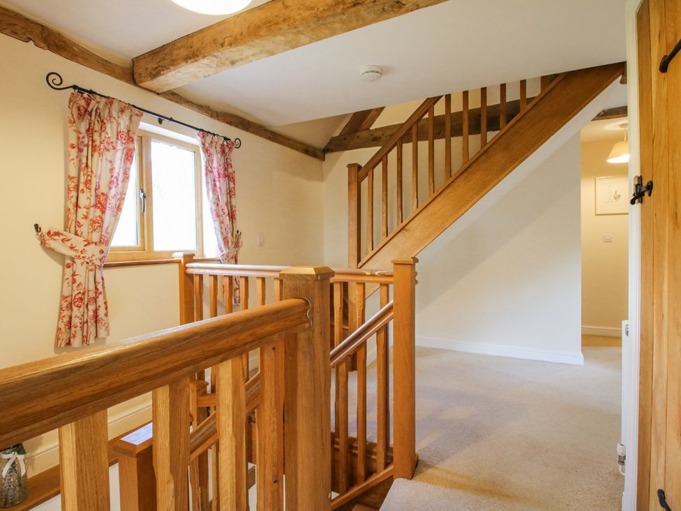 A hallway with a staircase and window at The Hayloft Bleddfa near Knighton