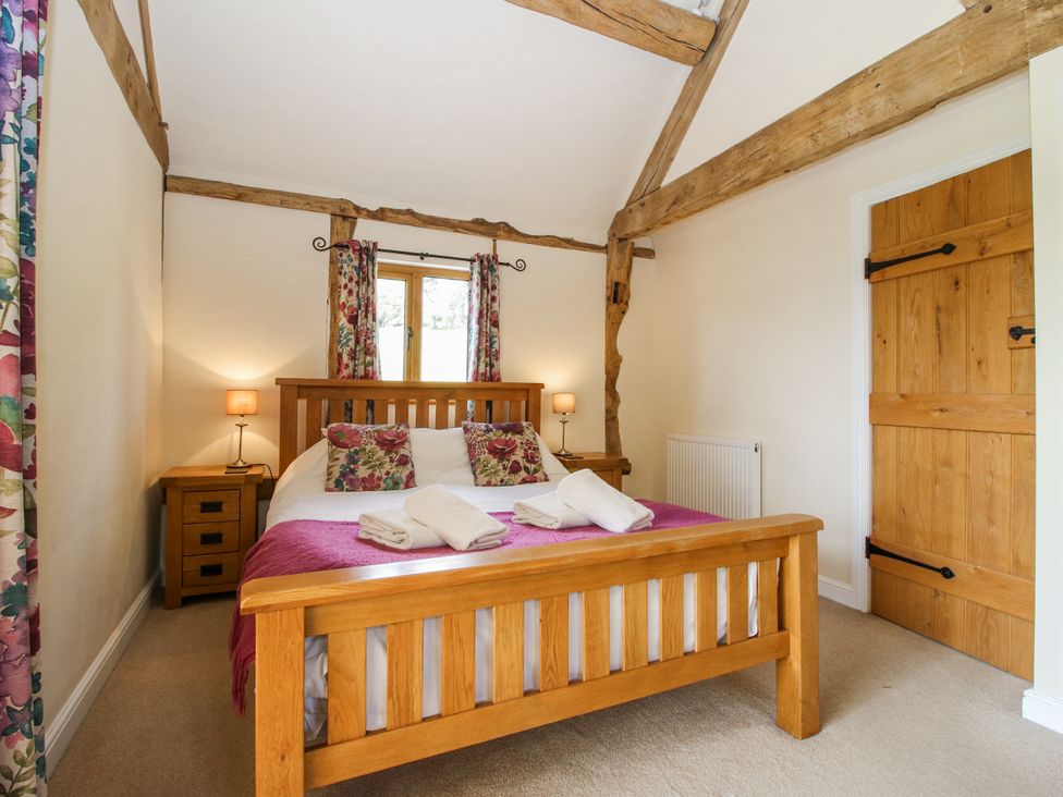 A bedroom with a bed and nightstand at The Hayloft Bleddfa near Knighton