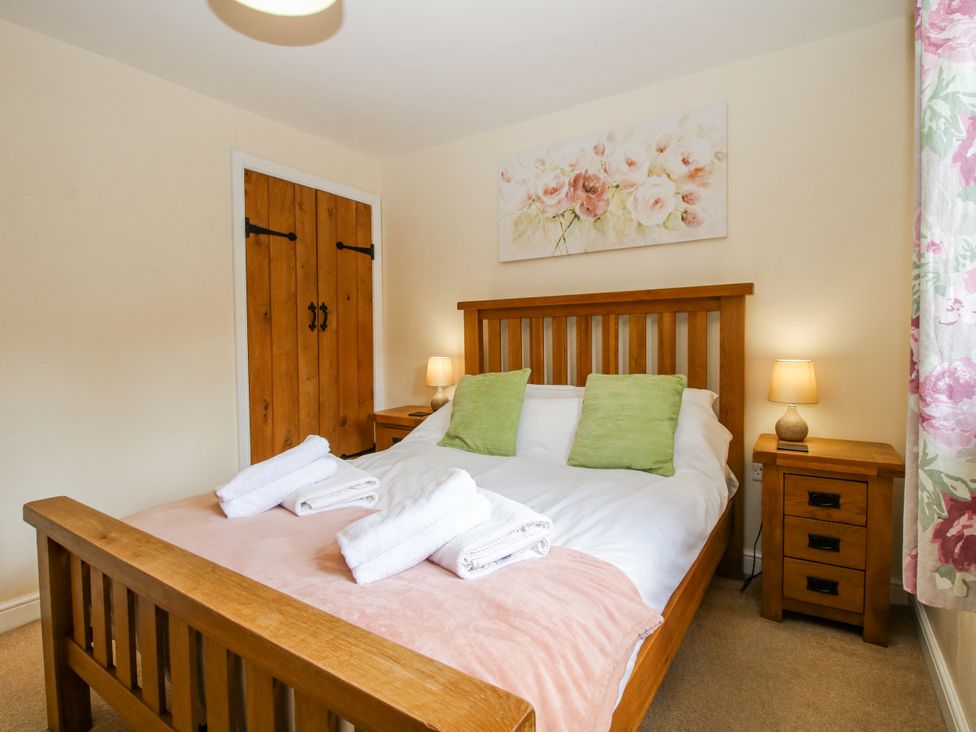 A bedroom with a bed and bedside table at The Hayloft in Bleddfa near Knighton