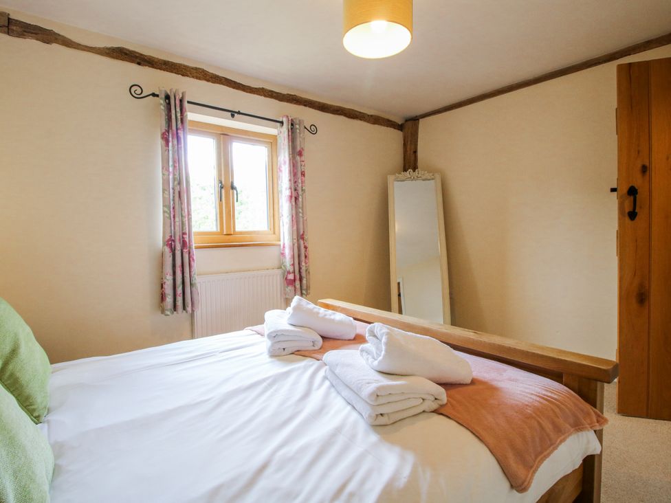 A bedroom with a bed and towels at The Hayloft in Bleddfa near Knighton