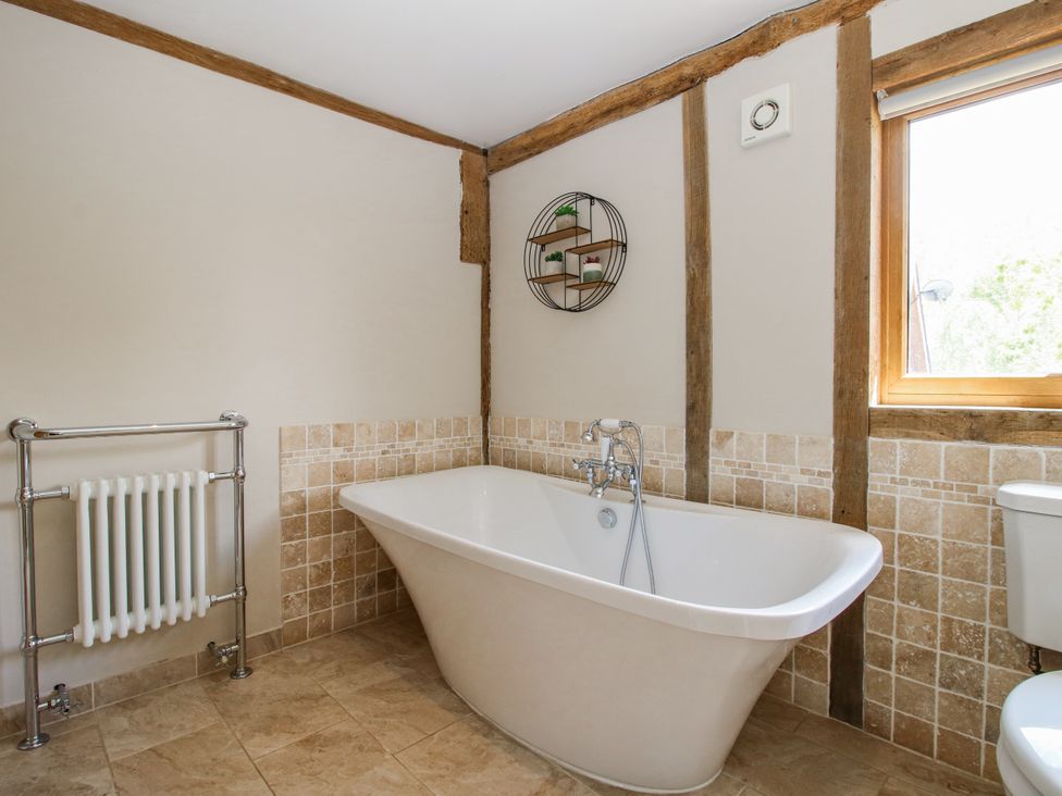 A bathroom with a bathtub, toilet and radiator at The Hayloft Bleddfa near Knighton