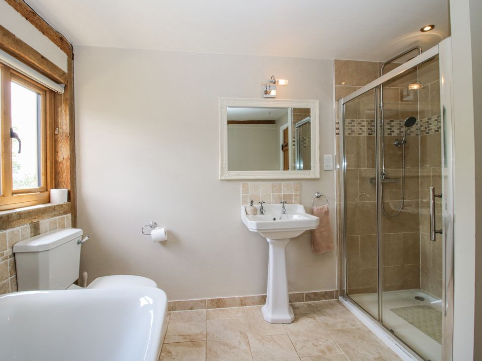 A bathroom with a bathtub, toilet, sink, and shower at The Hayloft in Bleddfa near Knighton