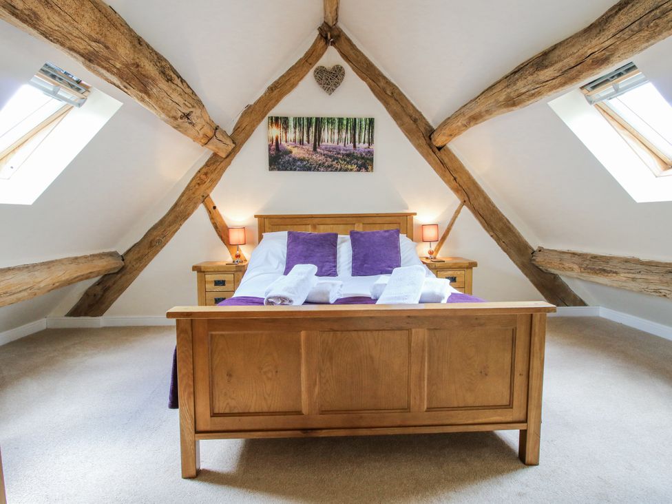 A bedroom with a bed and wooden beams at The Hayloft in Bleddfa near Knighton