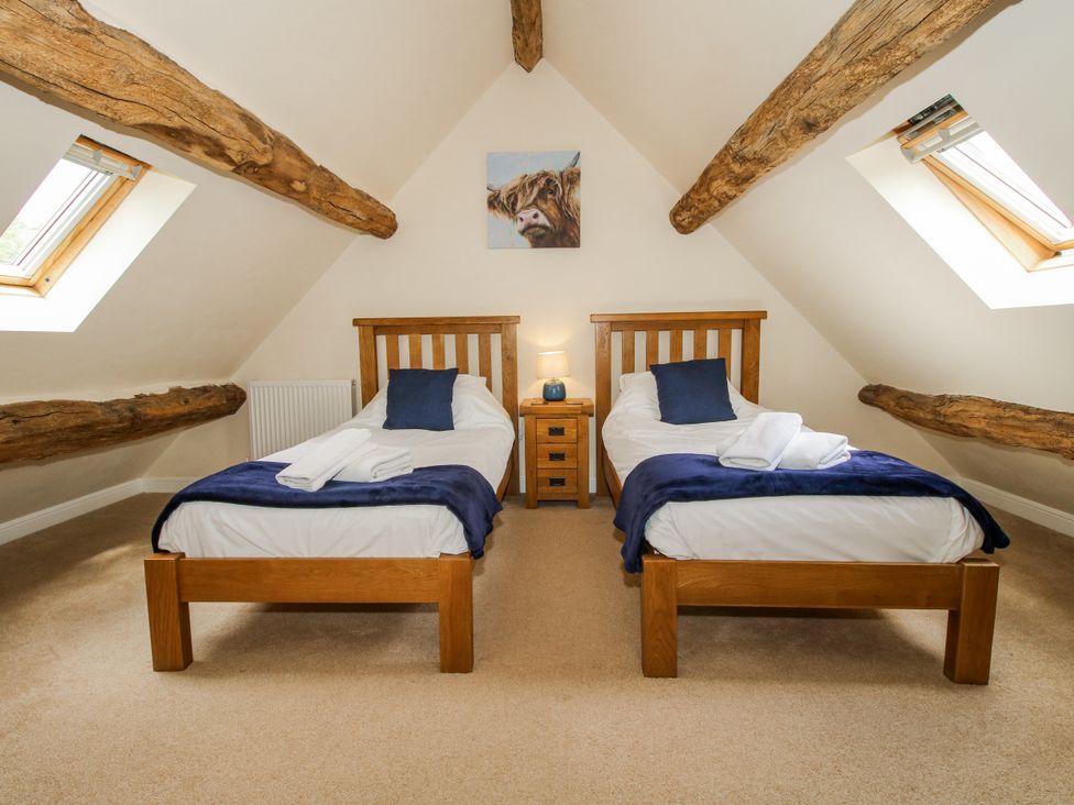 A bedroom with two single beds and a skylight at The Hayloft in Bleddfa near Knighton