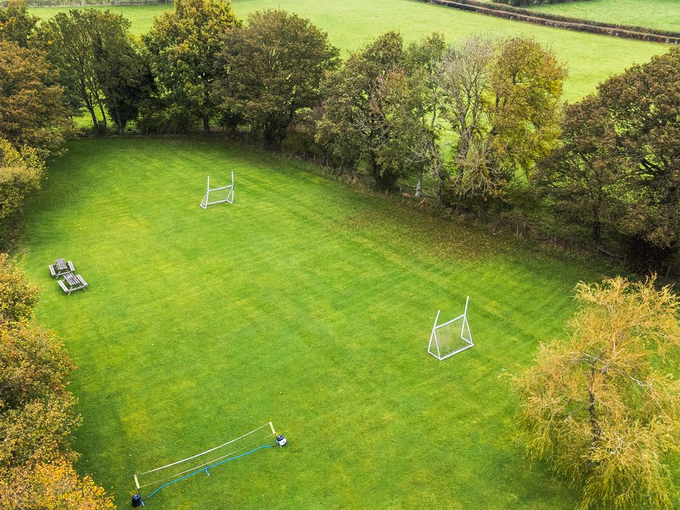 An outdoor area with goal posts and benches at Ty Newydd in Llangadfan