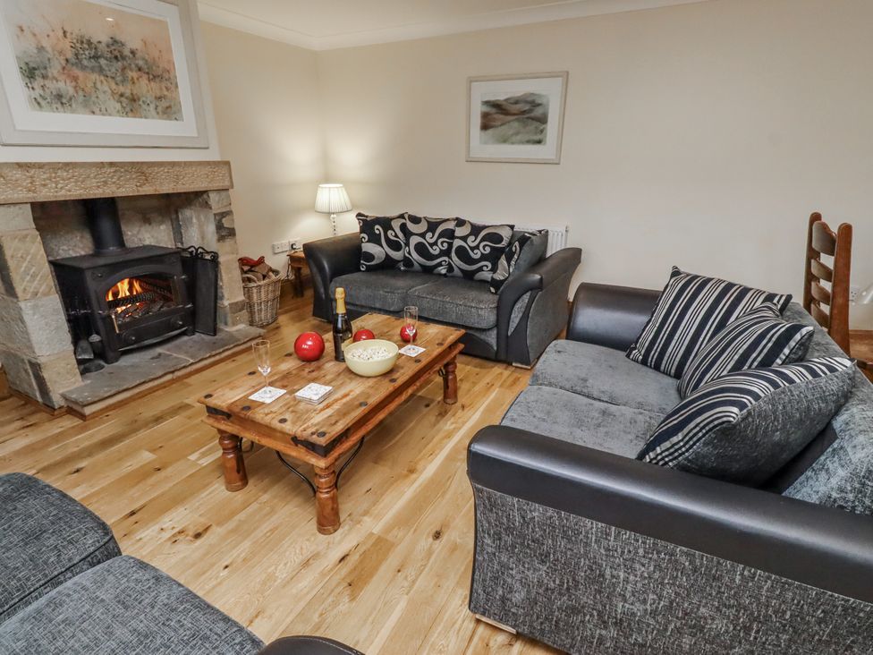 A living room with a fireplace and sofas at High Hemmel House in Embleton