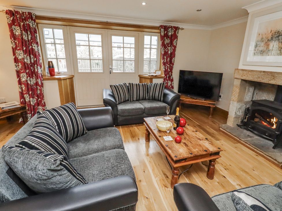 A living room with a sofa and fireplace at High Hemmel House in Embleton