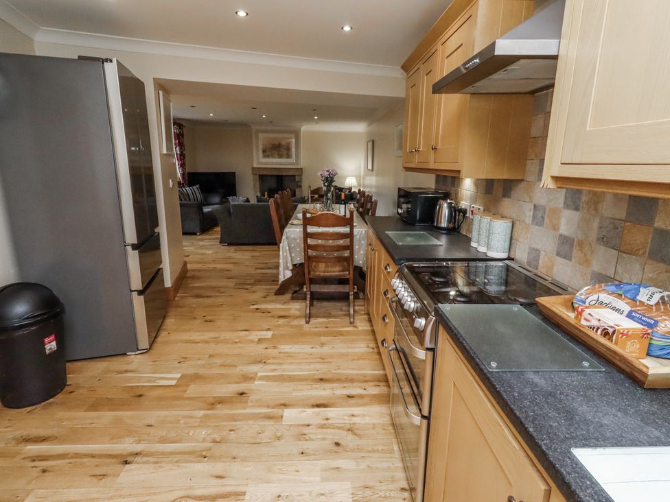 A kitchen with appliances and a dining area at High Hemmel House in Embleton