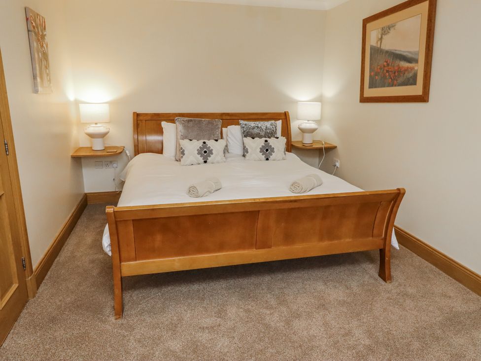 A bedroom with a bed and bedside lamps at High Hemmel House in Embleton
