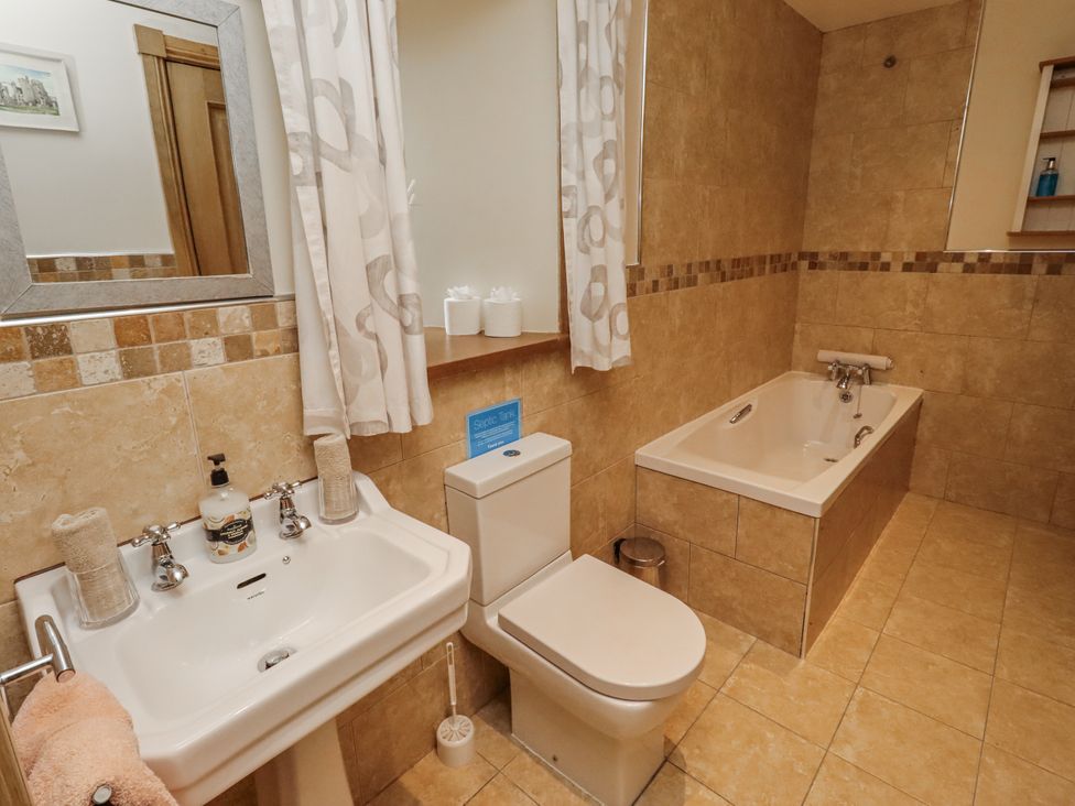 A bathroom with sink, toilet, and bathtub at High Hemmel House in Embleton