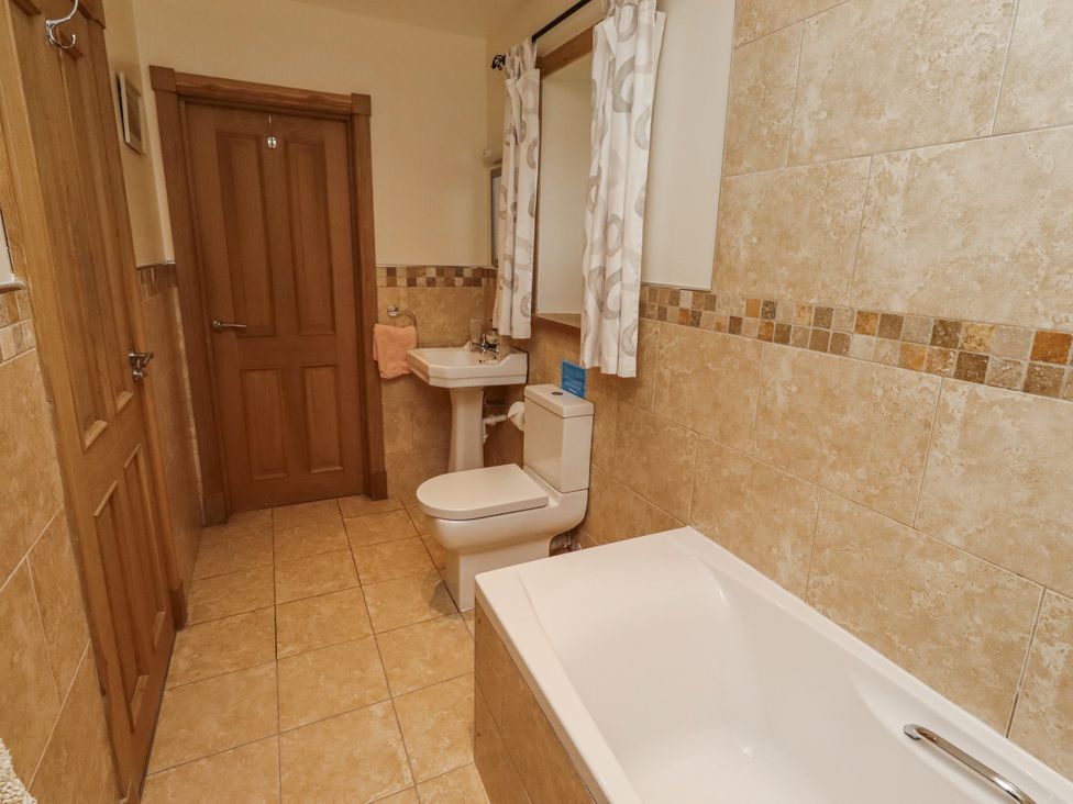A bathroom with a sink, toilet, and bath tub at High Hemmel House in Embleton