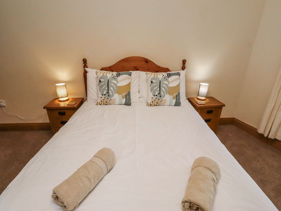 A bedroom with a bed and bedside tables at High Hemmel House in Embleton