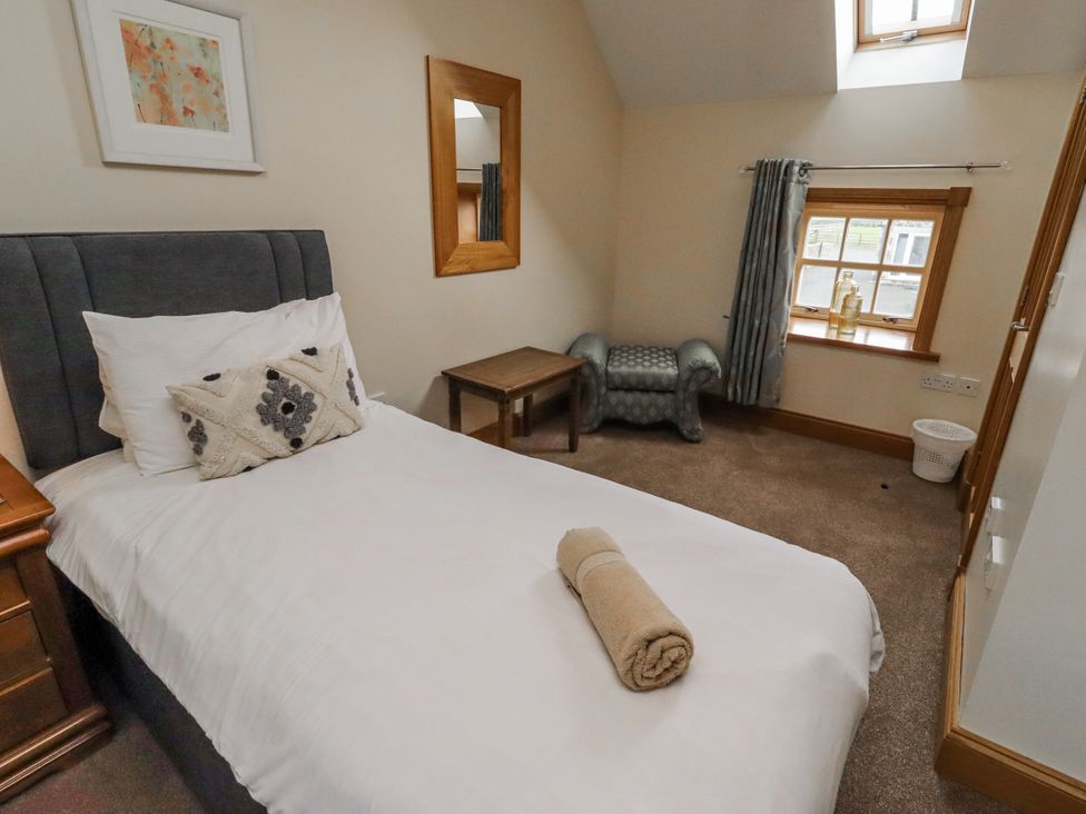 A bedroom with bed and table at High Hemmel House in Embleton