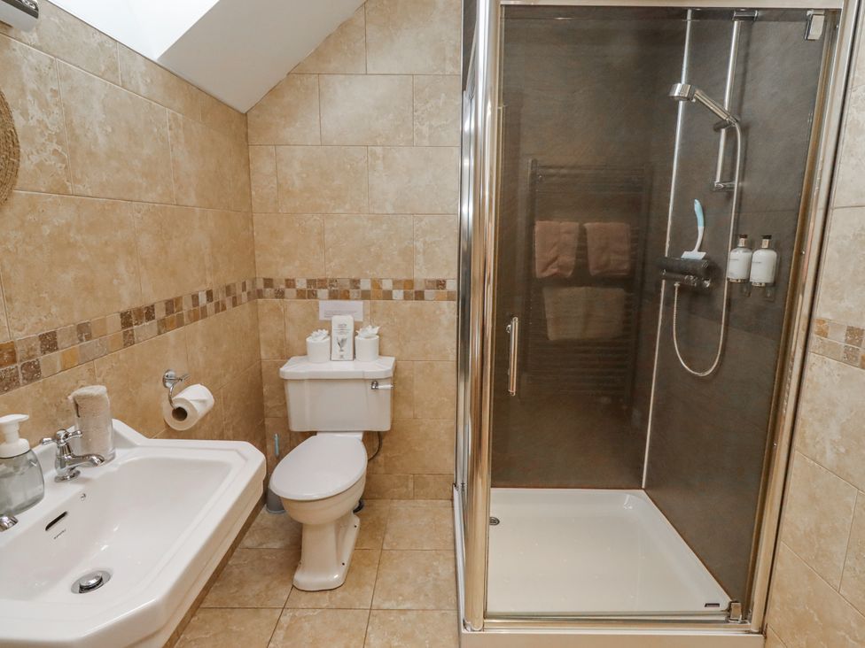 A bathroom with a sink, toilet, and shower at High Hemmel House in Embleton