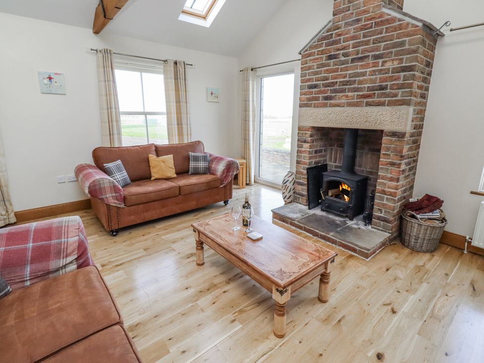 A living room with a fireplace and a sofa at Home Stead Cottage in Embleton