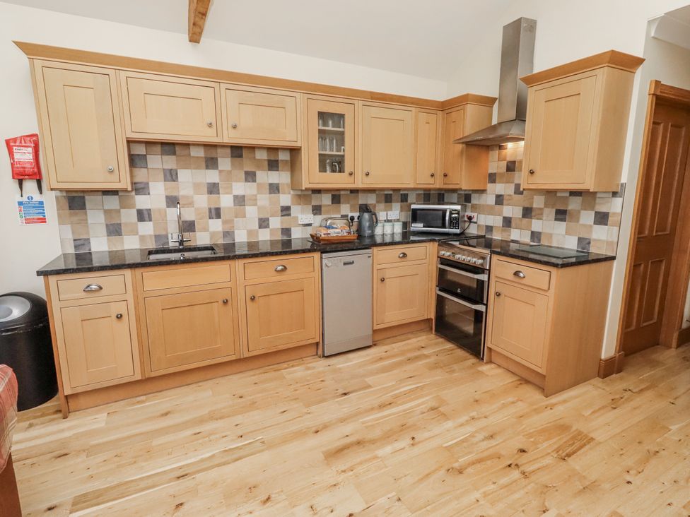 A kitchen with cabinets and appliances at Home Stead Cottage in Embleton