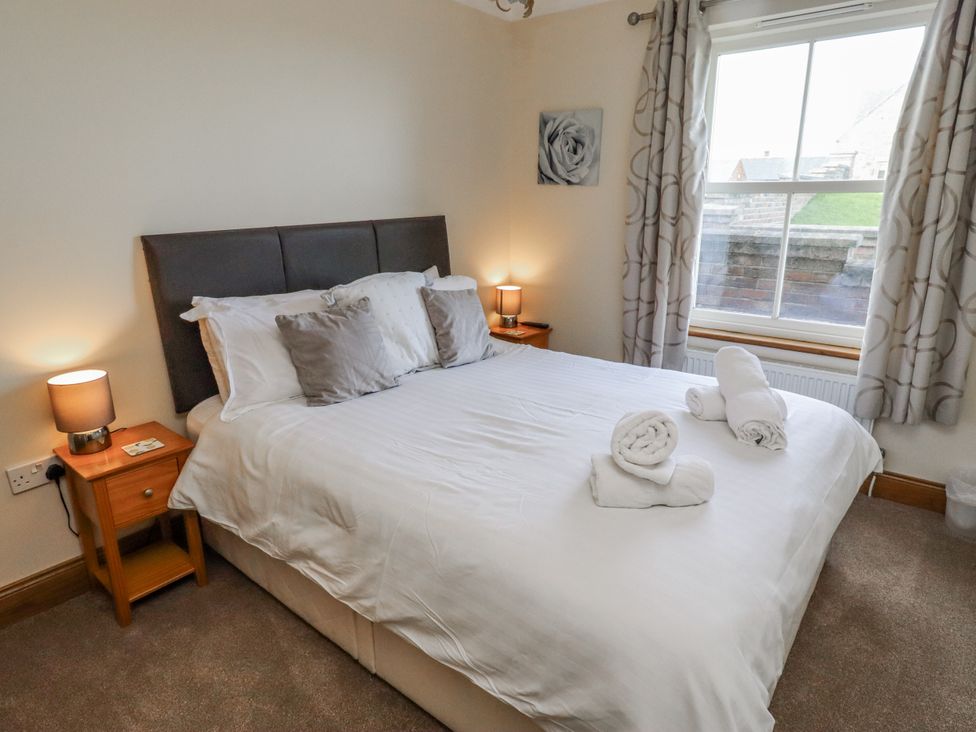 A bedroom with a bed and bedside tables at Home Stead Cottage in Embleton