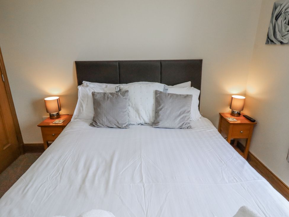 A bedroom with a bed and bedside tables at Home Stead Cottage in Embleton