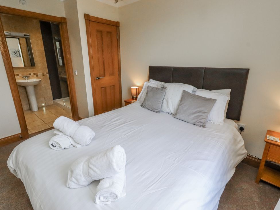 A bedroom with a bed and a bathroom view at Home Stead Cottage in Embleton