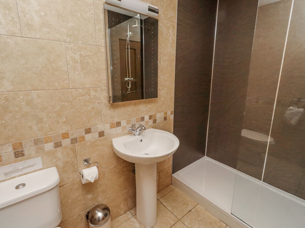 A bathroom with a sink, toilet, and shower at Home Stead Cottage in Embleton