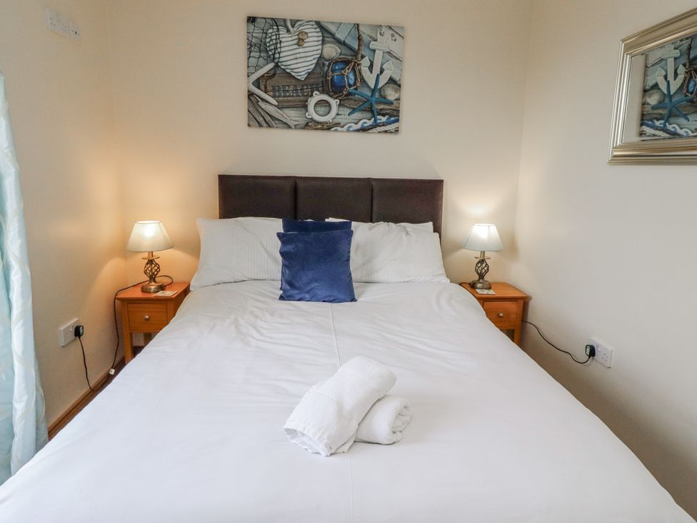 A bedroom with a bed and lamps at Home Stead Cottage Embleton