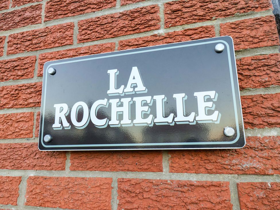 A nameplate labeled La Rochelle on a brick wall at La Rochelle Whitby