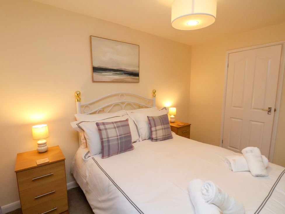 A bedroom with a bed and nightstands at La Rochelle in Whitby