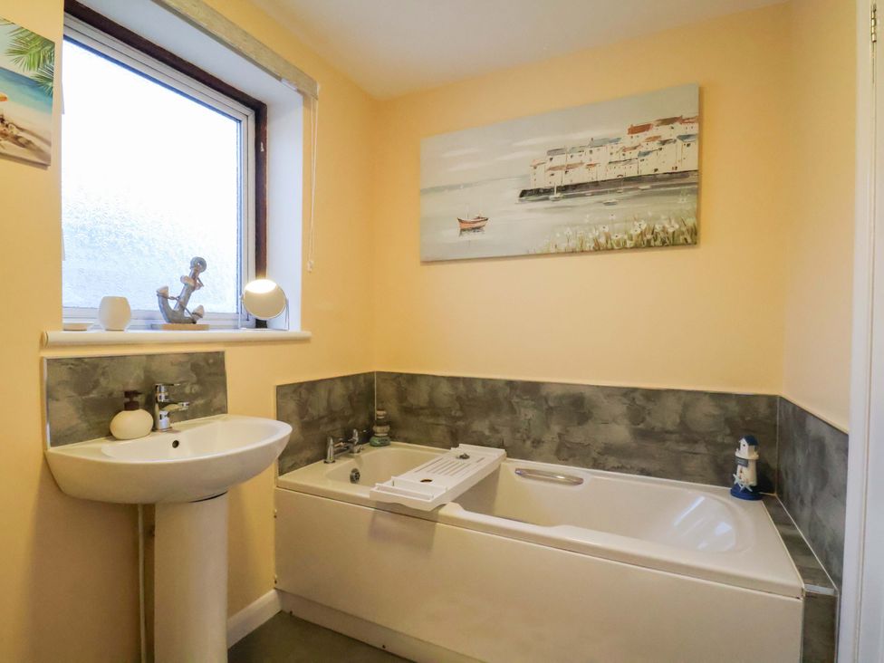 A bathroom with a bathtub and sink at La Rochelle in Whitby