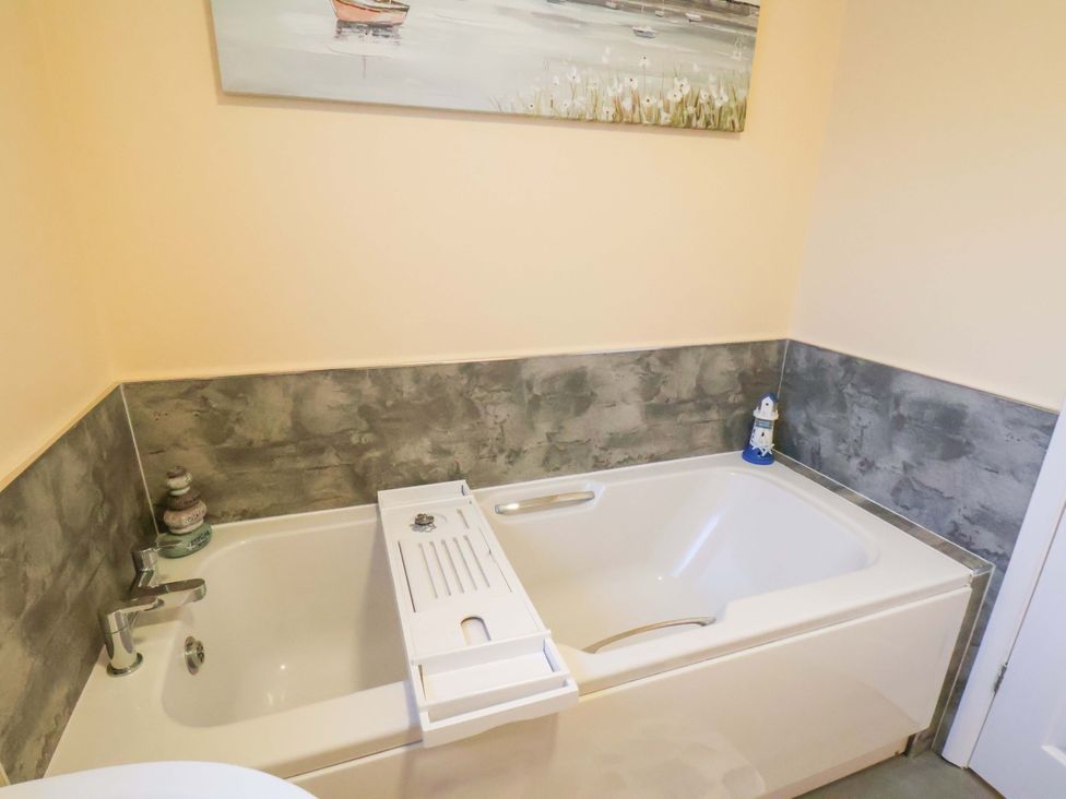 A bathroom featuring a bathtub and wall art at La Rochelle in Whitby