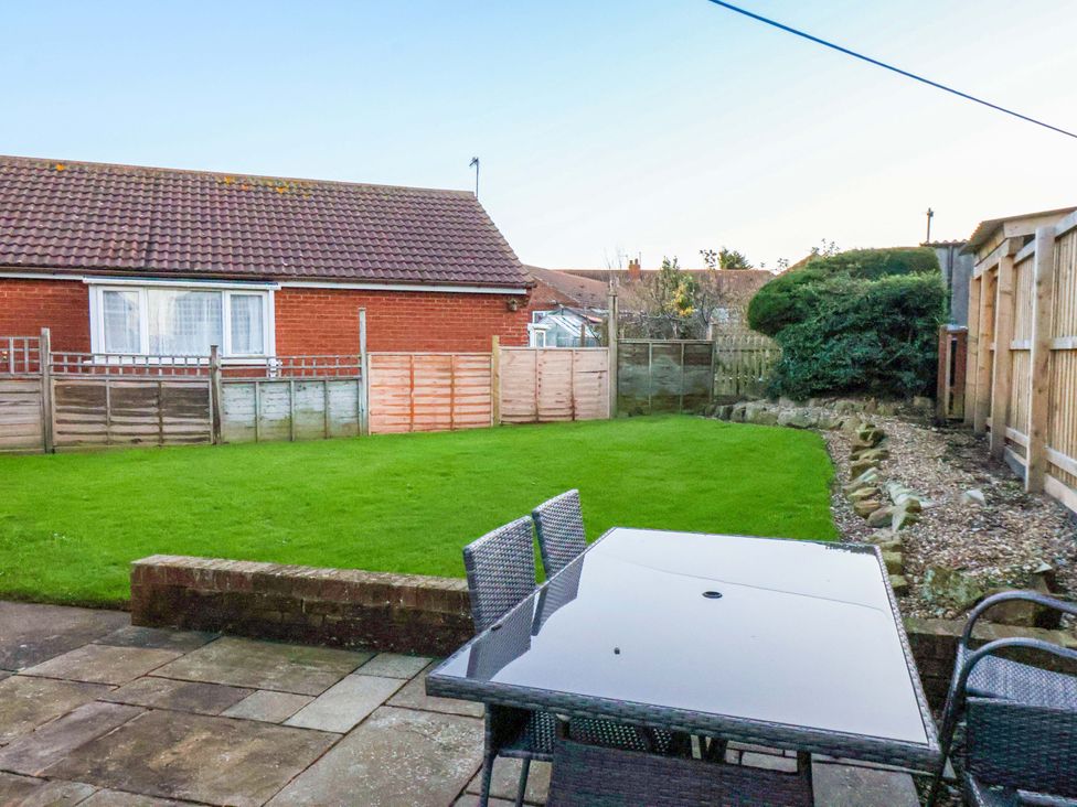 A garden with a table and chairs at La Rochelle in Whitby