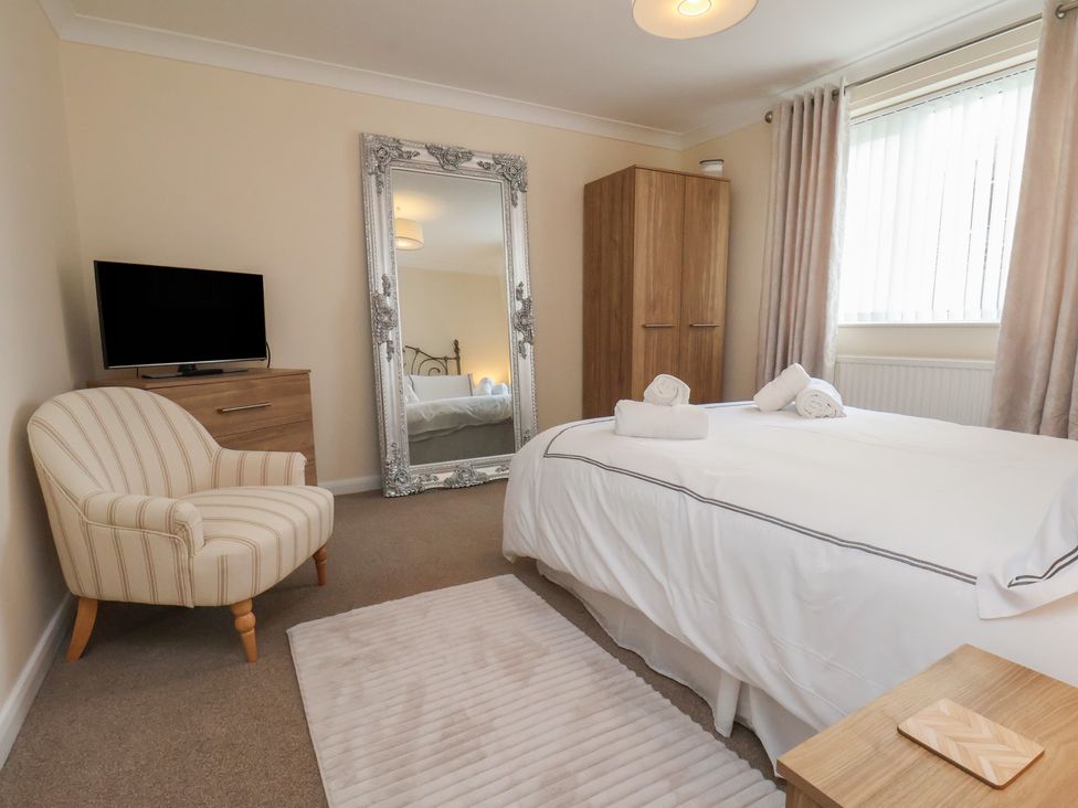 A bedroom with a bed and mirror at La Rochelle in Whitby