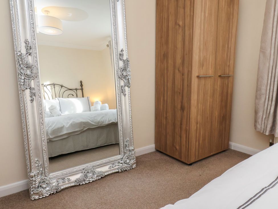 A bedroom with a mirror and wardrobe at La Rochelle in Whitby