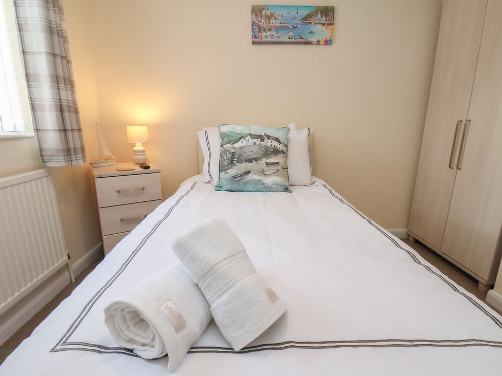 A bedroom with a bed and towels on top at La Rochelle in Whitby