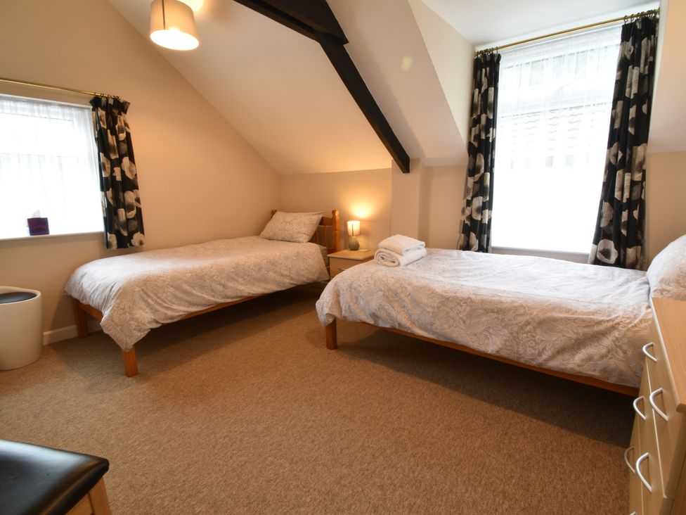 A bedroom with two beds and a lamp at Kingfisher in Blaenwaun