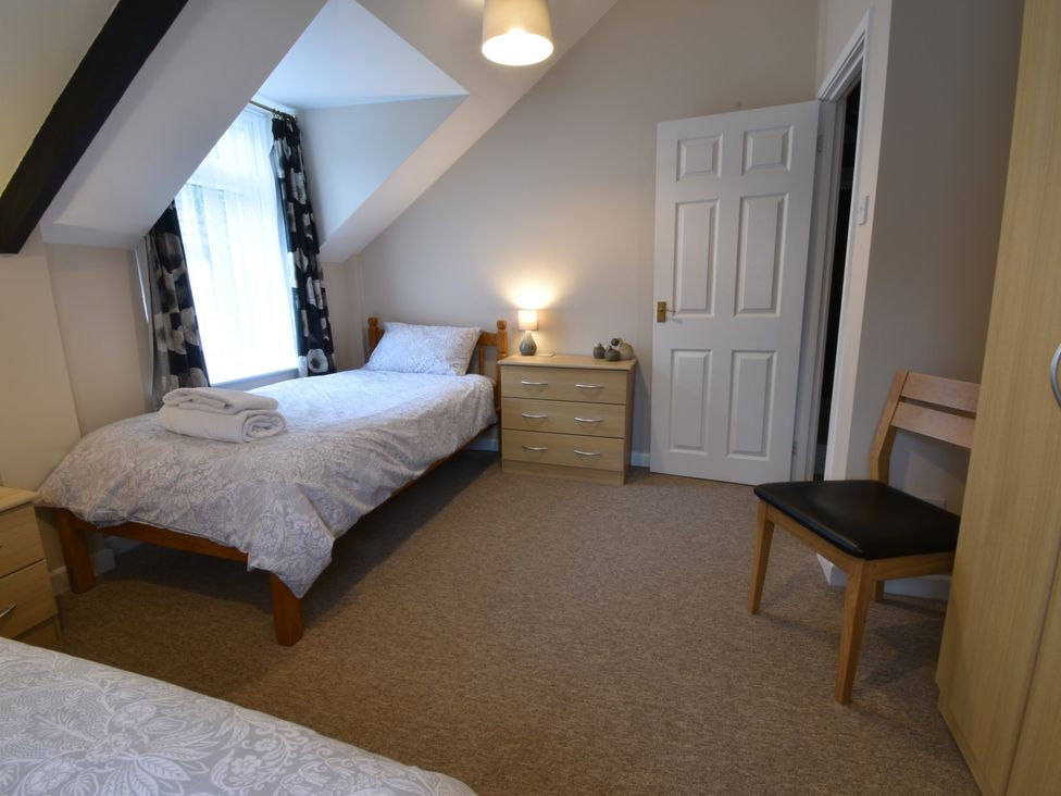 A bedroom with a single bed and furniture at Kingfisher in Blaenwaun
