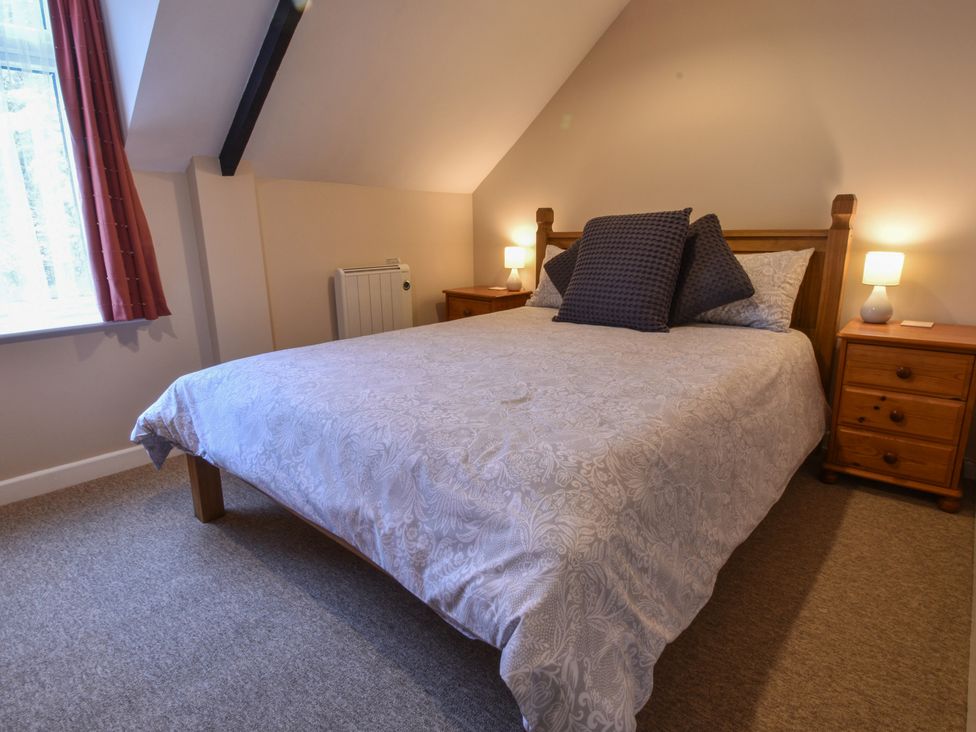 A bedroom with a bed and bedside tables at Kingfisher in Blaenwaun